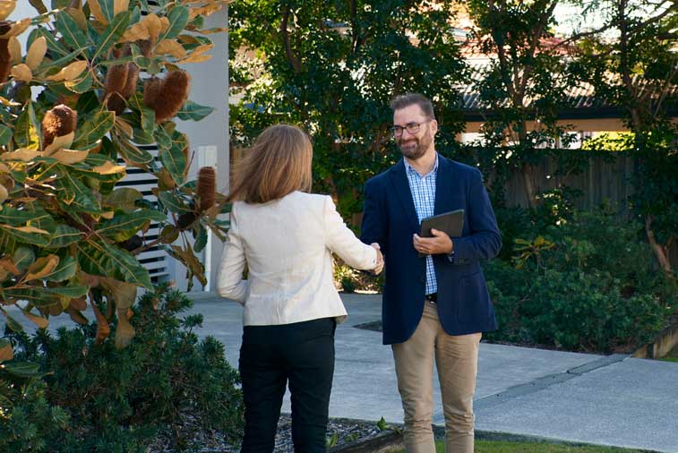 Brisbane property valuer meeting client outside house for valuation service